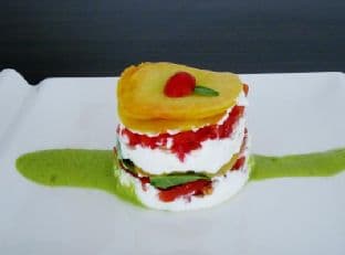 Peaches, tomatoes, and goat cheese layer cake with a peach-basil sauce